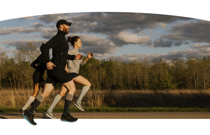 Gruppe von Läufern in Sportkleidung, die draußen trainieren für einen gesunden Start ins neue Jahr